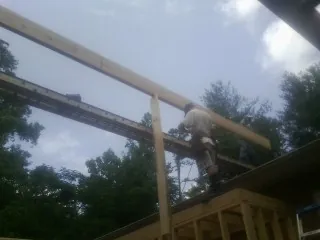 Carpenter setting a ridge beam over a new addition frame — Ice Dam Removal by Roofing Brothers in Meherrin