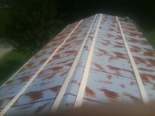Rusted metal roof panels with new wood purlins before replacement — Storm Damage Roof Repair in Meherrin by Roofing Brothers