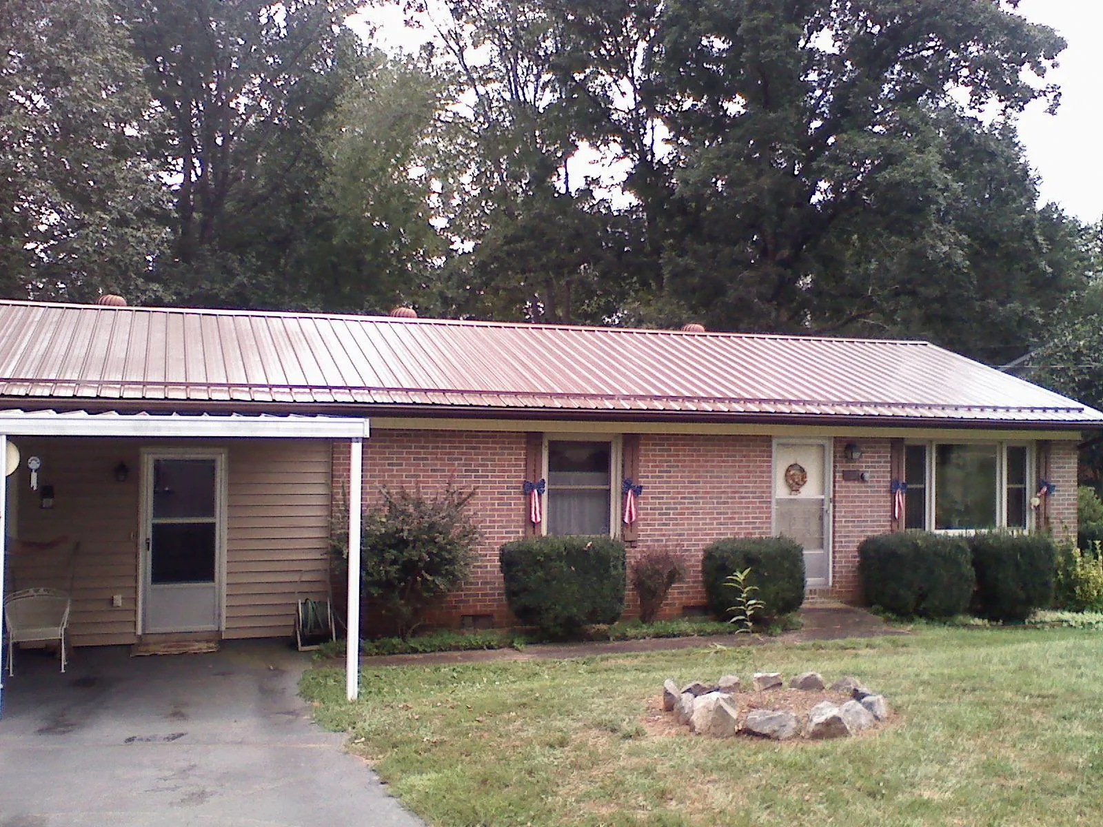 Bronze metal roof and carport on a brick ranch home — Roof Repair work by our crew in Meherrin