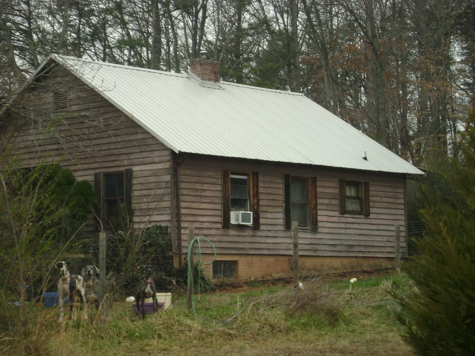 White metal roof on an old wood sided farmhouse, from a Metal Roof Installation job in Meherrin